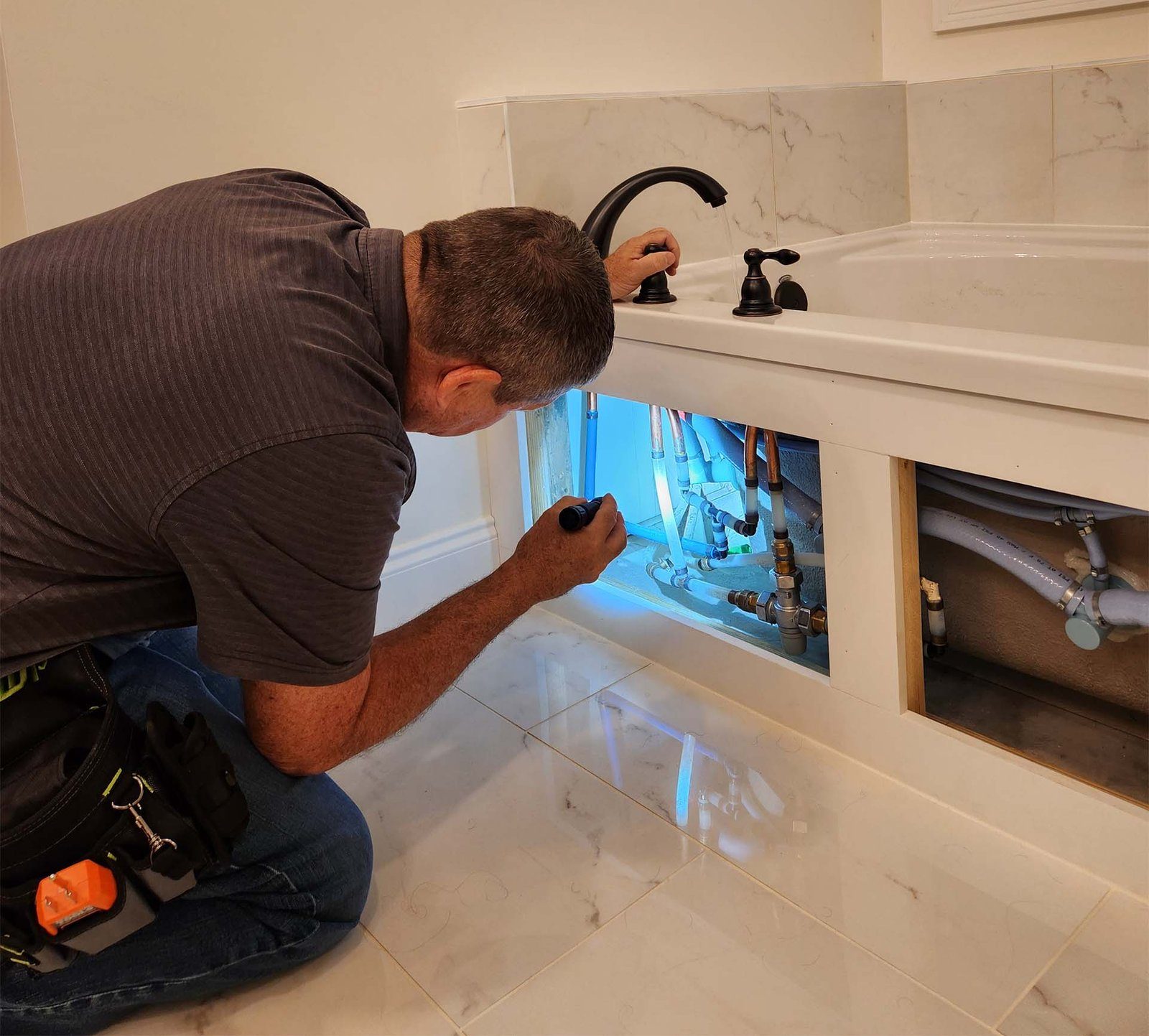 Checking plumbing under a sink